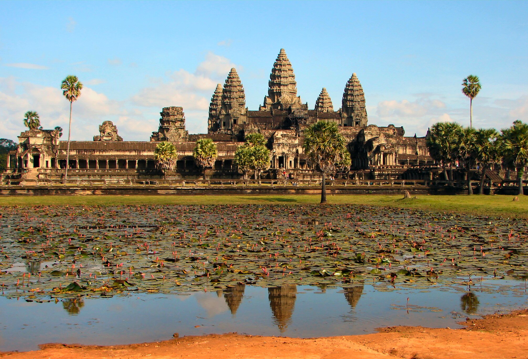 Angkor Wat temple towers and reflecting pond in late-afternoon light